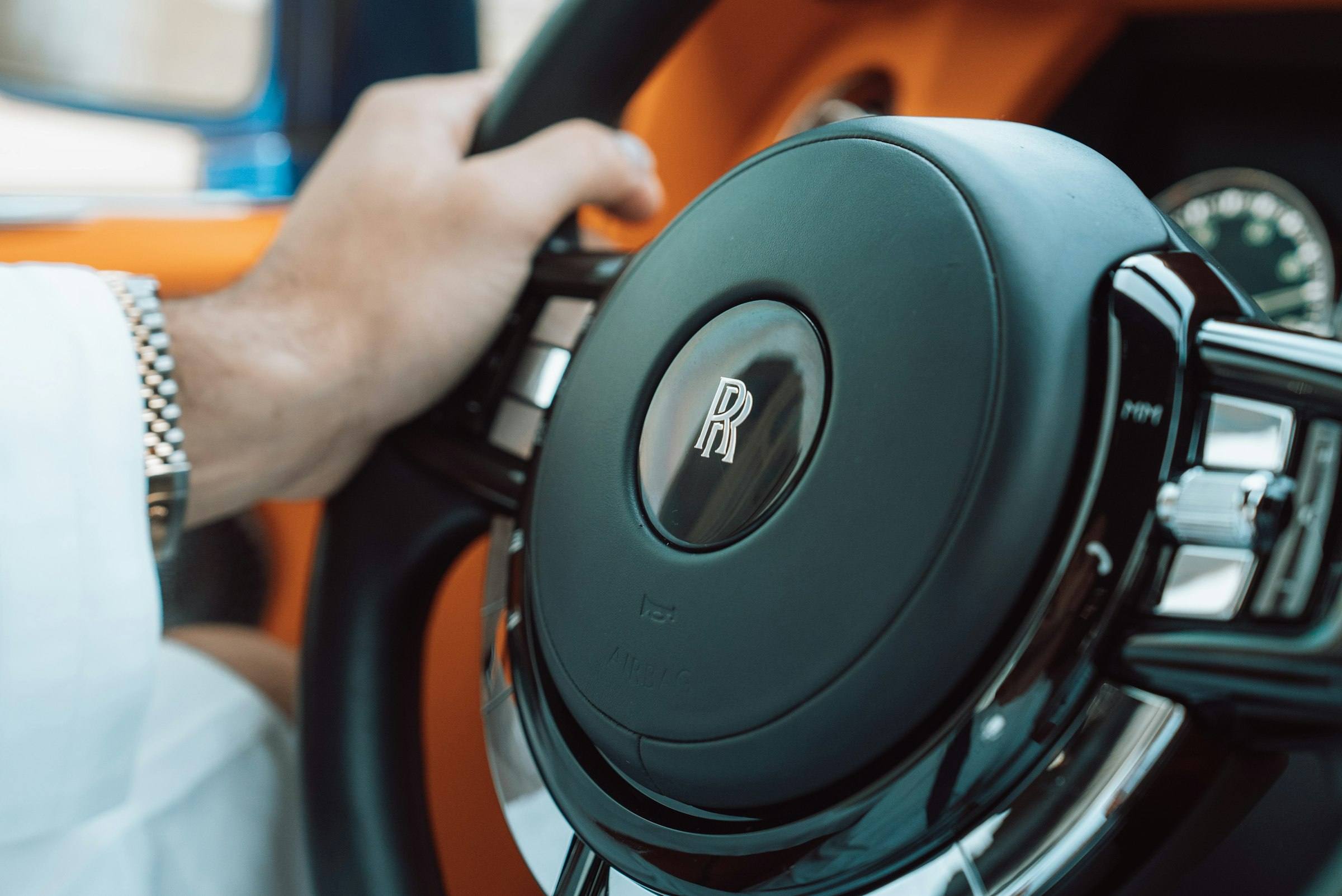 Hand on the steering wheel of a Rolls-Royce